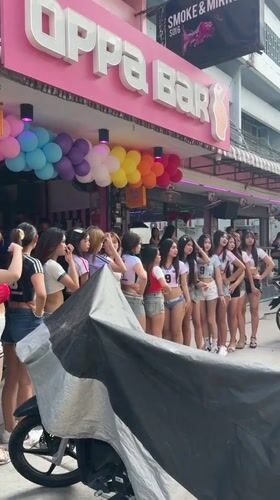 Daytime street activity recorded outside Pattaya bars, pedestrians walking