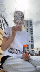 Woman blows bubbles on bench in Izhevsk