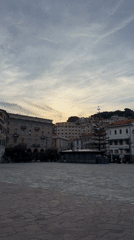 Woman takes selfie in Sanremo piazza under cloudy skies