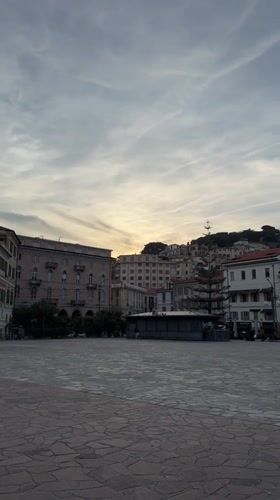 Woman takes selfie in Sanremo piazza under cloudy skies