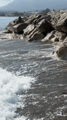 Sunny afternoon along Estepona's coast: kayaks, waves, and old stone