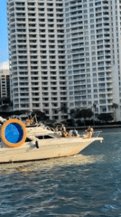 Evening Miami waterfront activity includes yachts, autonomous vehicles, construction