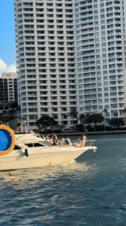 Evening Miami waterfront activity includes yachts, autonomous vehicles, construction