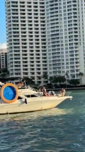 Evening Miami waterfront activity includes yachts, autonomous vehicles, construction