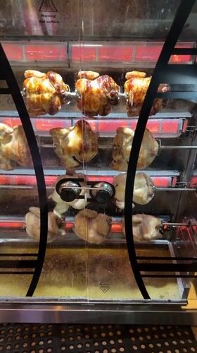 Rotisserie chickens turning in a Denpasar oven
