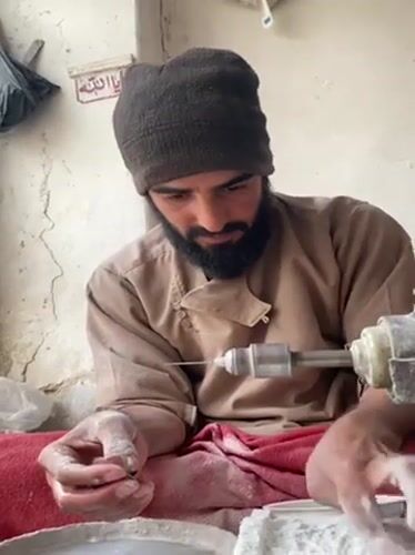 Afghan artisan polishes gemstones in traditional Kandahar workshop