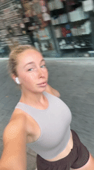 Selfie video moment in Tel Aviv, earbuds in, casual outfit.