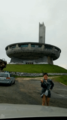 Tourist visits iconic Buzludzha Monument in foggy Bulgarian mountains