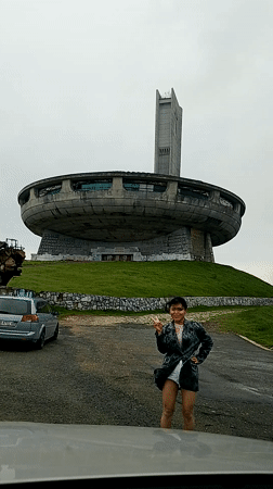 Tourist visits iconic Buzludzha Monument in foggy Bulgarian mountains