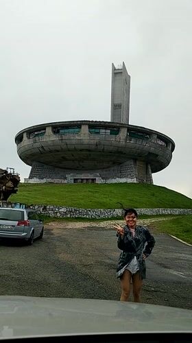 Tourist visits iconic Buzludzha Monument in foggy Bulgarian mountains