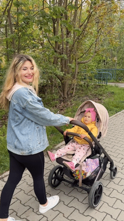 Woman pushes baby stroller on path in Wisła, Poland