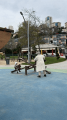 Woman helps child on seesaw in Başakşehir park