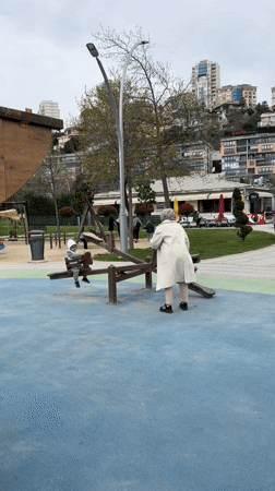 Woman helps child on seesaw in Başakşehir park