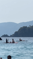 Busy beach day in Fethiye features swimming, boating, paragliding activities