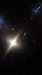 Late-night crowd dances at Paris nightclub with geometric lighting
