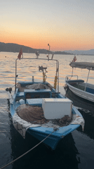 Fethiye harbor at golden hour, boats docked and quay busy