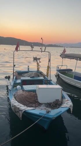 Fethiye harbor at golden hour, boats docked and quay busy