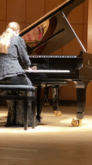 Blonde pianist performs on wooden stage in Moscow