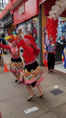 Traditional Andean dancers perform outside a La Victoria storefront