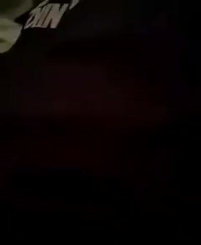 The video opens with a close-up shot of a black garment, possibly a t-shirt or sweatshirt, with the white Nike logo and text visible on the upper left portion. The lighting is dim, making it difficult to discern further details of the garment or the surrounding environment. As the video progresses, the camera moves, revealing a person's hand or arm in a light-colored fabric on the left side of the frame. The background remains largely black and indistinct. Towards the end of the clip, a patterned wall or surface becomes partially visible on the left, suggesting an indoor setting. The overall impression is of a brief, uninformative glimpse of clothing in low light conditions. No specific activity or event is discernible, and the context of Melitopol, Ukraine, does not provide any visible cues within the frame. There are no overt emotional expressions or clear indications of time of day or weather.
