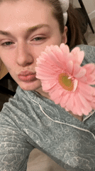 Woman poses with pink flower in pajamas in Kazan