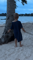 Child plays with sticks on Ko Phangan beach