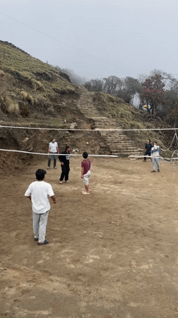 Volleyball game played on dirt court in Nepal village