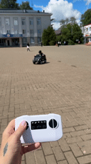 Child plays with toy Mercedes SUV in Russian square