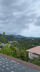 Woman views tropical coastline from Koh Phangan rooftop