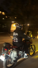Motorcyclists ride through Denpasar streets in evening hours