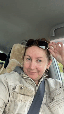Driver waves at camera while driving in Barnaul
