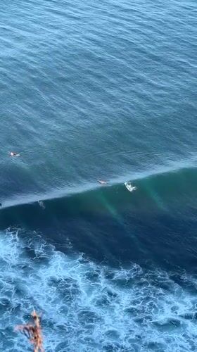 Surfers work a solid lineup off Kuta Selatan's coast