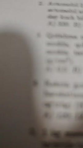 Here is a description of the video:

The video shows a person sitting at a table on which a printed worksheet is placed. The worksheet appears to be a physics test on dynamics with several multiple-choice questions. The person's legs are visible under the table. The background is not clear, but it seems to be an indoor environment. The camera appears to be close to the table and the paper is in focus.