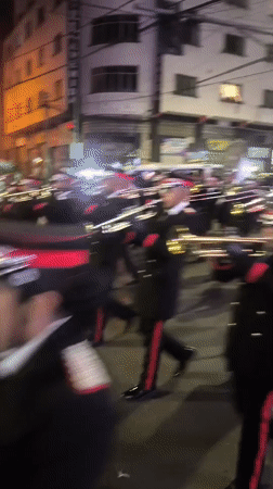 Nighttime street parade rolls through La Paz with brass band