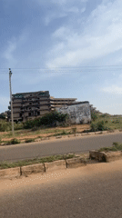 Two pedestrians pass abandoned building in Jos, Nigeria