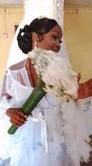 Bride poses with bouquet during wedding preparations