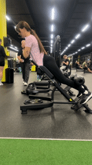 Woman performs weighted hyperextension exercises at Riga gym
