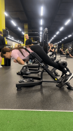 Woman performs weighted hyperextension exercises at Riga gym