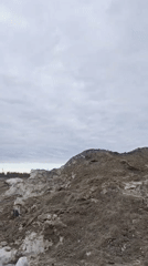 Earth mounds documented under overcast Russian landscape
