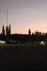 Dusk settles over an open field in Tambontunong, Indonesia