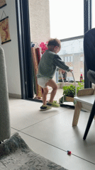 Toddler plays with plant-filled toy wheelbarrow in Kiryat Bialik
