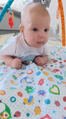 Baby enjoys tummy time on colorful playmat in Andreyevo