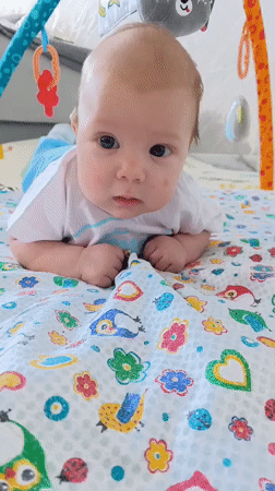 Baby enjoys tummy time on colorful playmat in Andreyevo