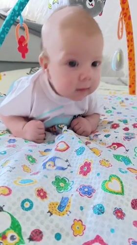 Baby enjoys tummy time on colorful playmat in Andreyevo