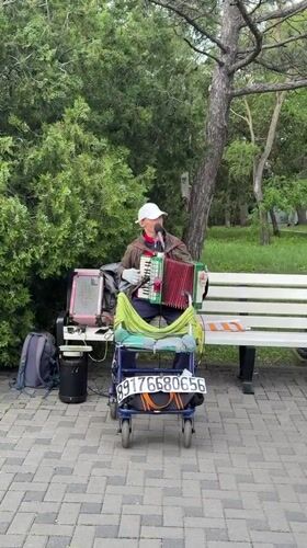 Street musicians perform accordion and saxophone in Anapa