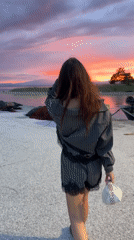 Woman enjoys sunset evening at Keramoti harbor restaurant