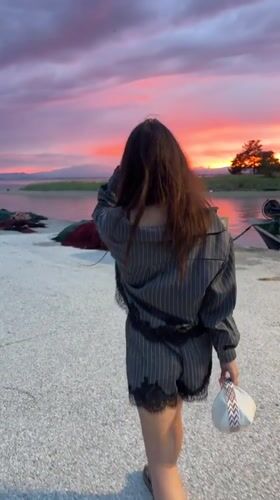 Woman enjoys sunset evening at Keramoti harbor restaurant