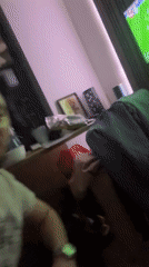 Man poses, watches soccer in Pernik living room