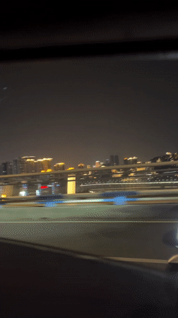 Nighttime drive through illuminated Yuzhong District captured on video