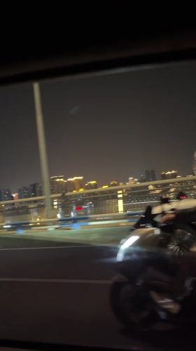 Nighttime drive through illuminated Yuzhong District captured on video